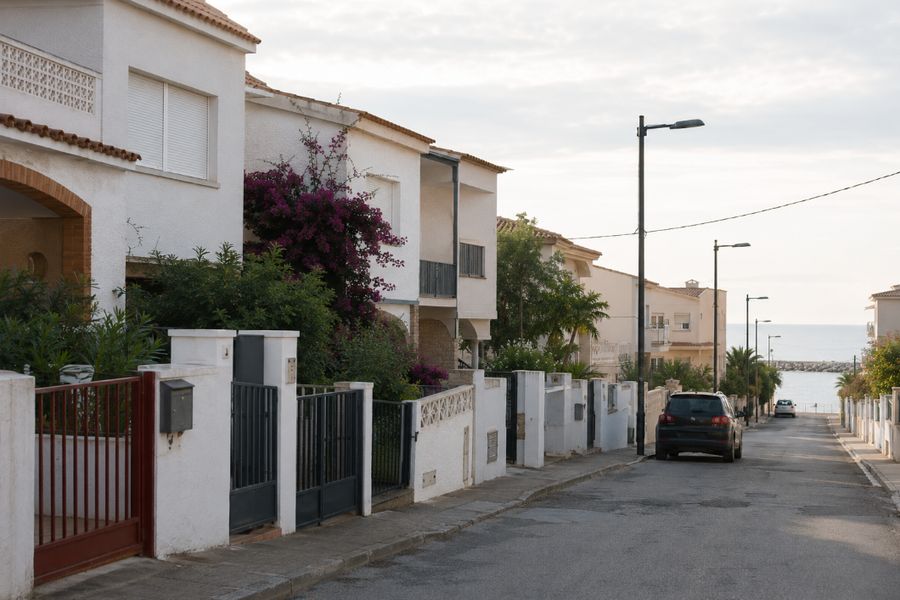Calle residencial de urbanización costera con el mar al fondo, en el Baix Penedès